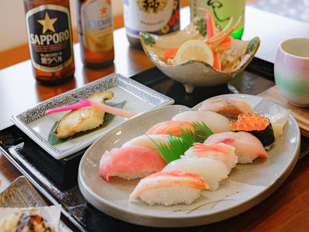 une table avec des sushis sur une table dans l'établissement Tabist Hotel Tetora Hakodate Station, à Hakodate
