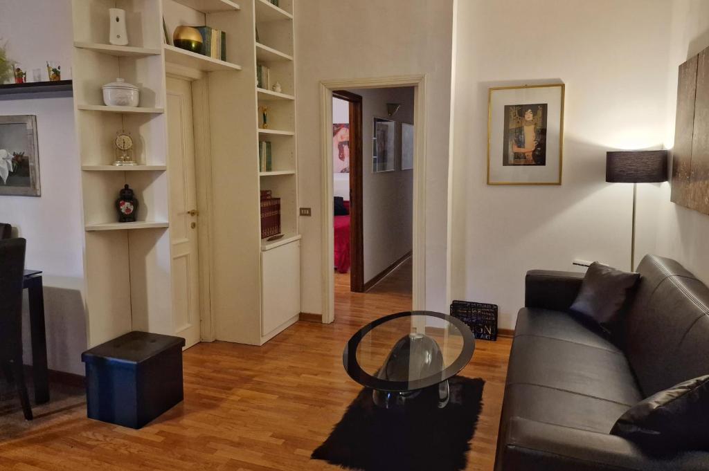 a living room with a couch and a glass table at Arezzo Charming Apartment in Arezzo
