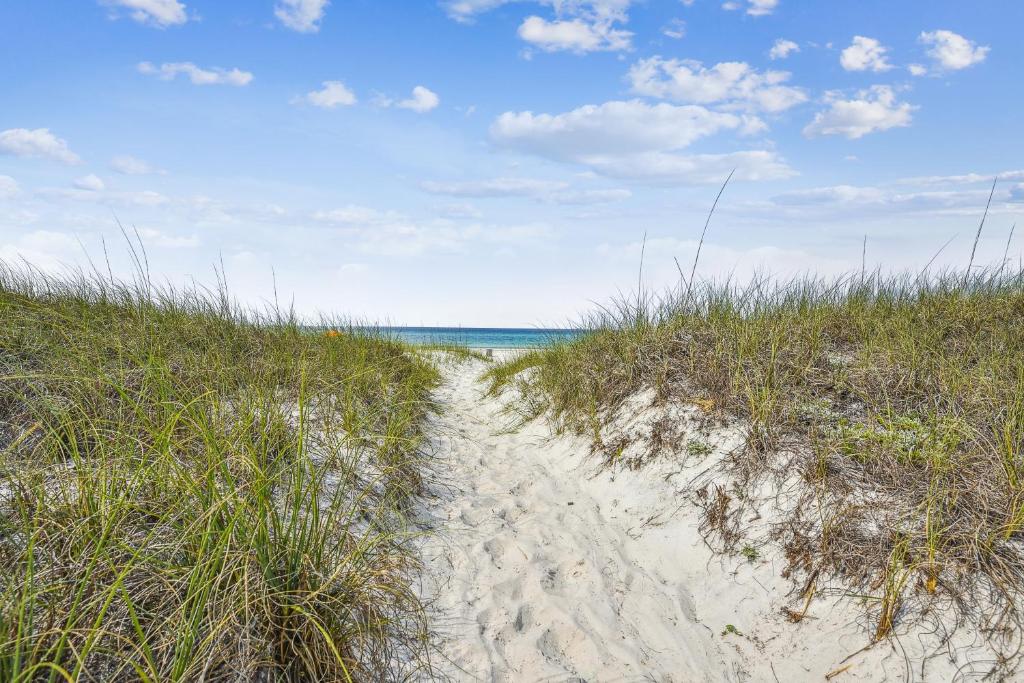un sentiero attraverso la sabbia su una spiaggia di Splash Pad by Book That Condo a Panama City Beach