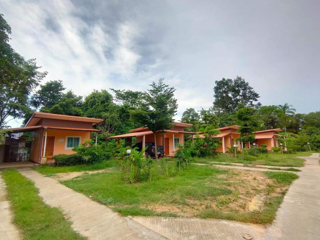 a row of houses with trees in the background at Tungngoen Resort in Ban Som Poi