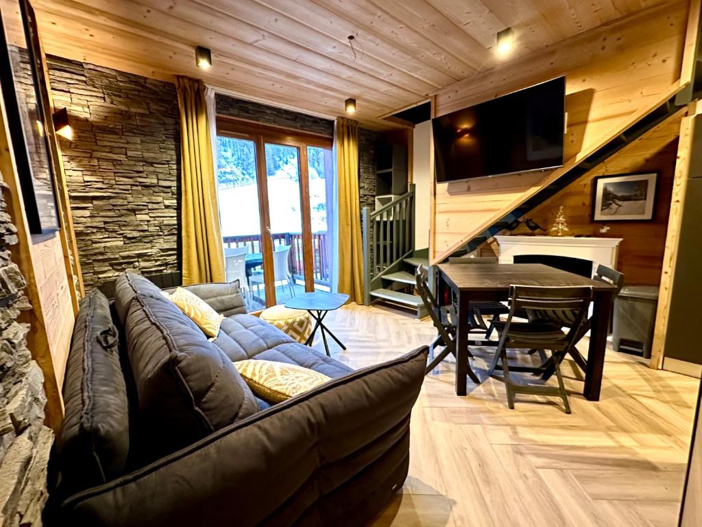 a living room with a couch and a table at Duplex rénové - 2 chambres 7 personnes vue pistes in Les Orres