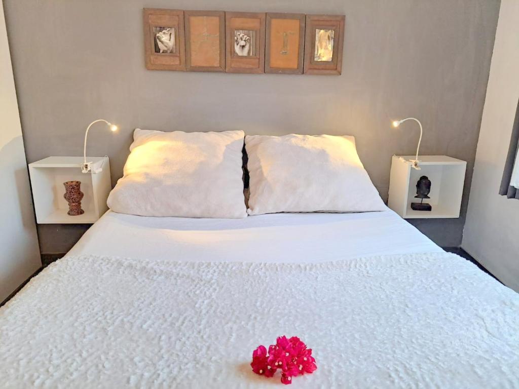 Un dormitorio con una cama blanca con una flor roja. en Badalona playa Barcelona en Badalona