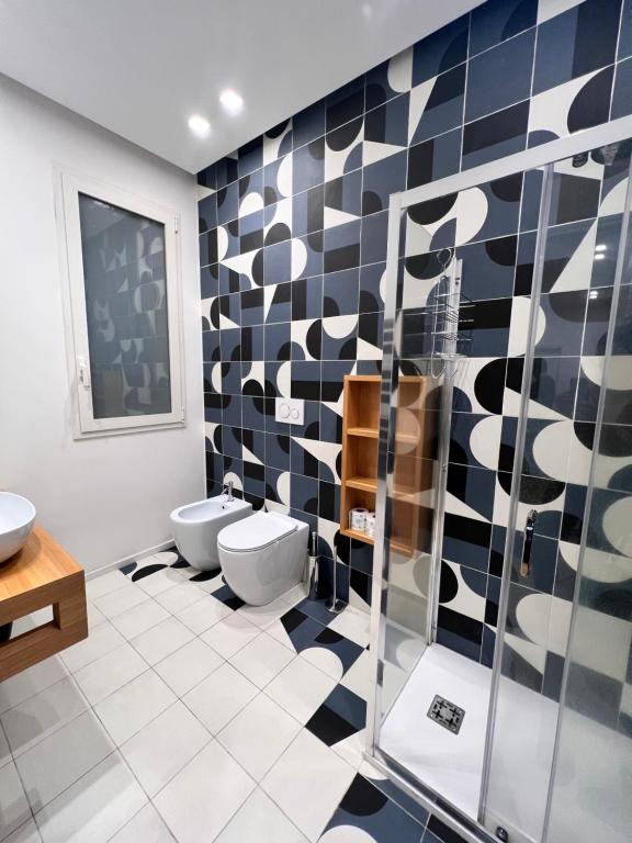een badkamer met 2 toiletten en zwarte en witte tegels bij Ermes Apartment - Historic Centre Catania in Catania