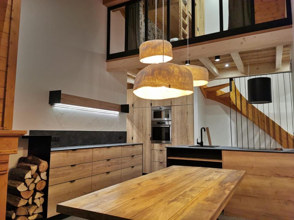 a kitchen with a wooden table and a staircase at Arcs 1950 , CALM Comme A La Montagne in Arc 1950