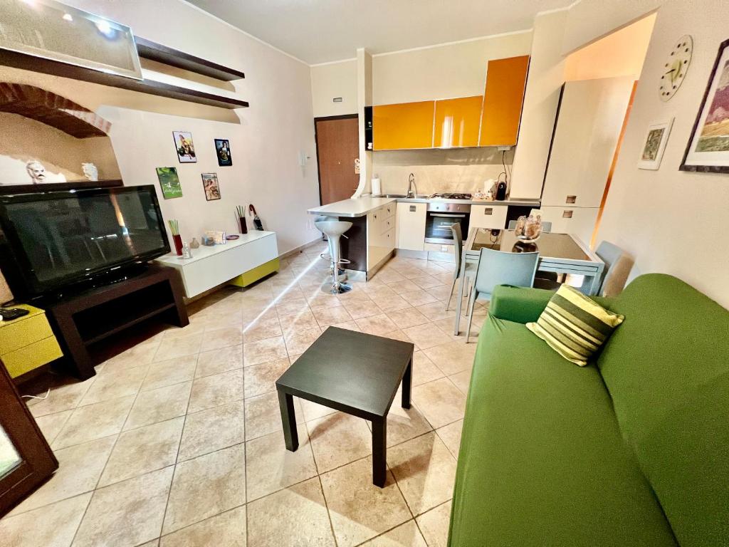 ein Wohnzimmer mit einem grünen Sofa und einer Küche in der Unterkunft Catania Duomo Shine in Catania