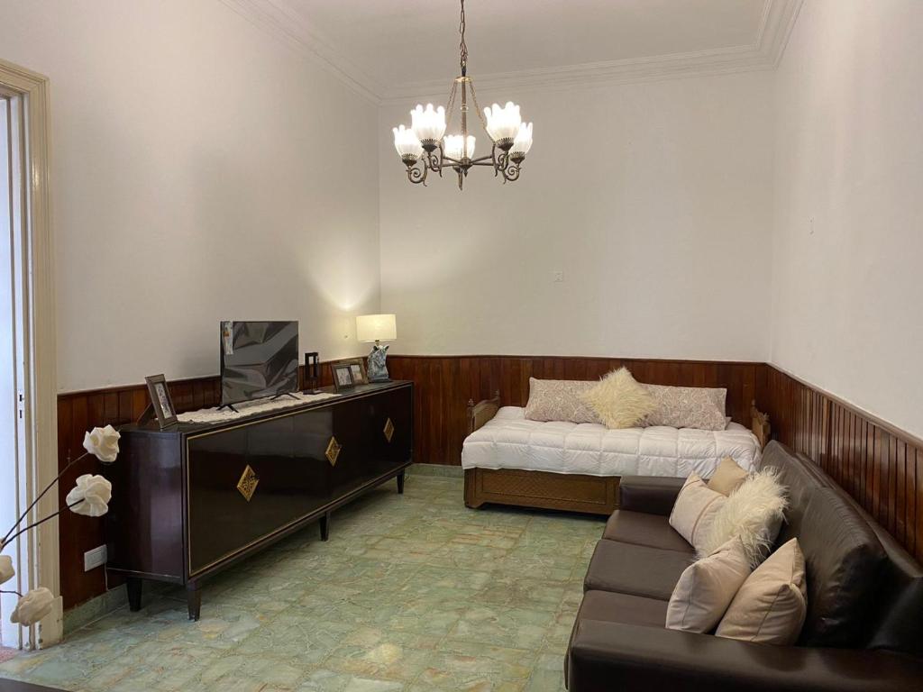 sala de estar con sofá y cama en Casa De Vacaciones Estilo Marplantense Temporada 2023 en Mar del Plata