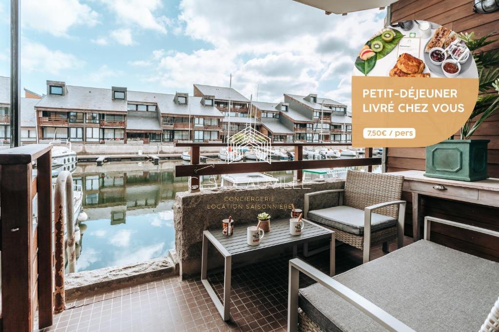 a patio at a hotel with a table and chairs at Le Ponton C.L.S Deauville in Deauville