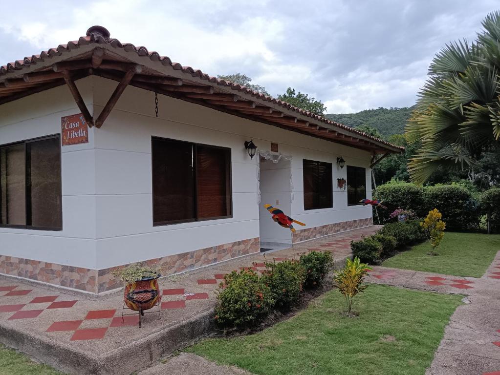 een wit huis met een tuin ervoor bij Casa libella in Carmen de Apicalá