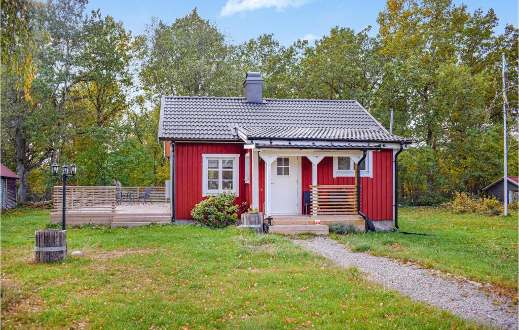 uma pequena casa vermelha com um alpendre e um quintal em Awesome Home In Lckeby With Kitchen 