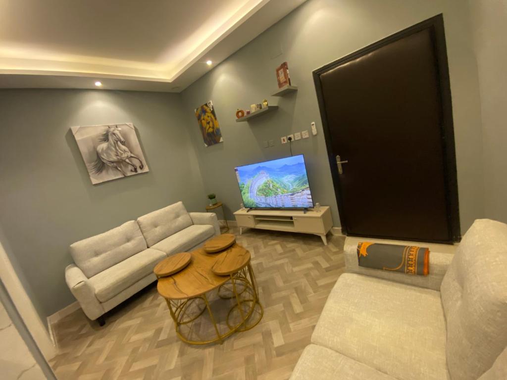 a living room with a couch and a flat screen tv at شقة بدخول ذاتي in Riyadh