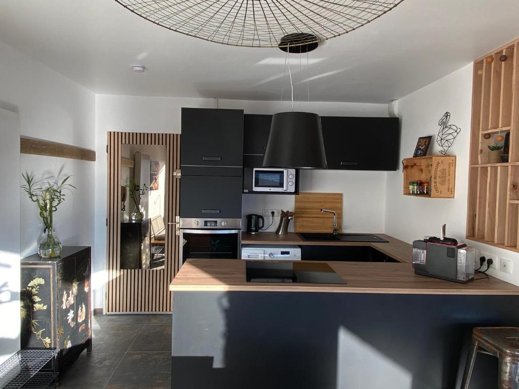 a kitchen with black cabinets and a counter top at La Kaz montagne in Briançon