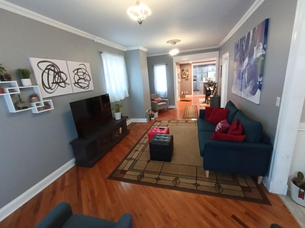 sala de estar con sofá azul y almohadas rojas en Cozy Updated 3-BR apartment near Peace Bridge, en Buffalo