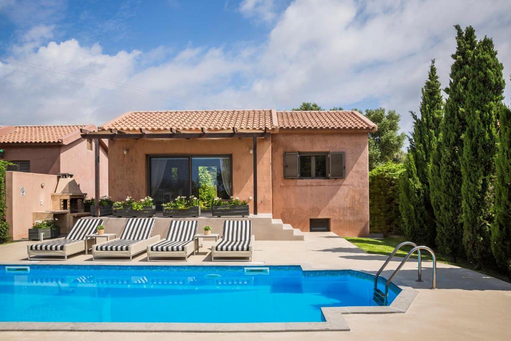 een villa met een zwembad en een huis bij Sotiris villas in Svoronata