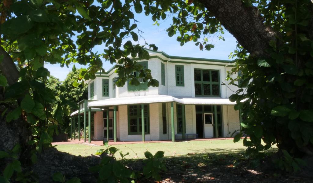 duży biały dom z oknami i drzewami w obiekcie Oceania House Hotel w mieście Bantam Village