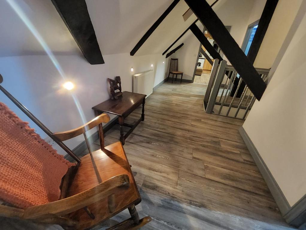 einen Flur mit einer Treppe mit einem Stuhl und einem Tisch in der Unterkunft The Olde Chapel 2 Bedroom Flat in Market Deeping