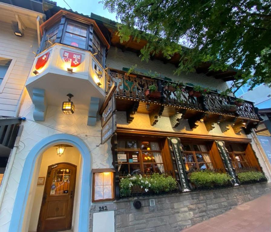 un edificio con un balcón con plantas. en Hostería Suiza - Ex Casita Suiza en San Carlos de Bariloche
