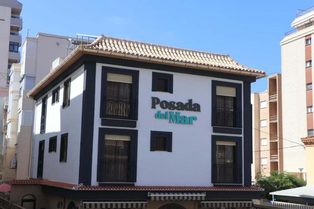 un bâtiment avec un panneau sur son côté dans l'établissement 201 I Posada del Mar I Encantador hostel en la playa de Gandia, à Los Mártires