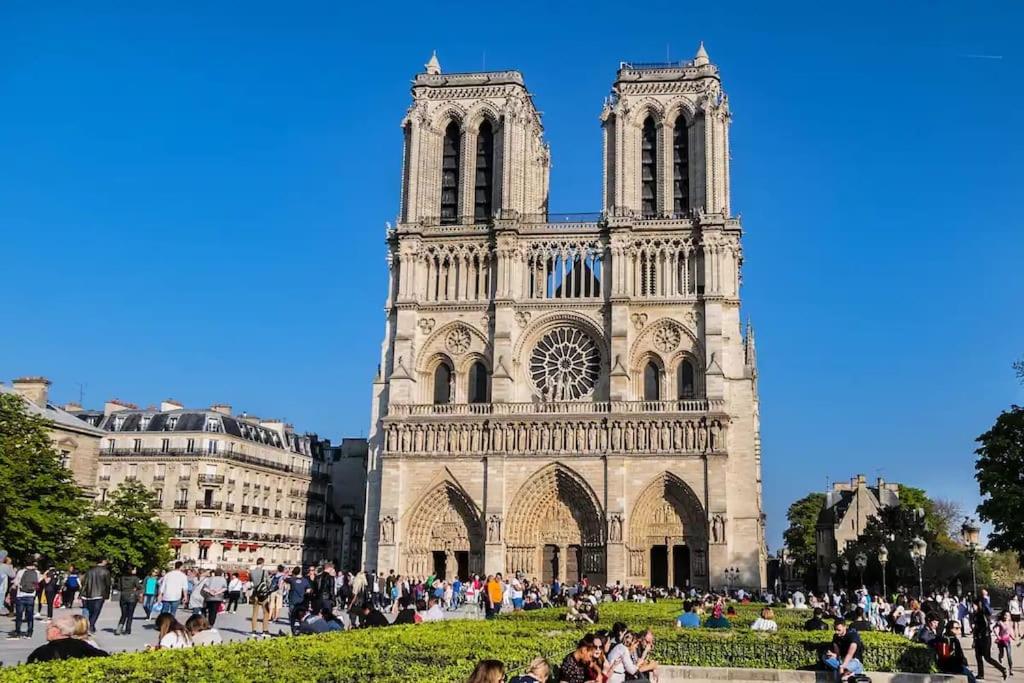 a group of people sitting in front of a cathedral at Cozy - Free Parking - 15mn from Paris Montparnasse in Clamart