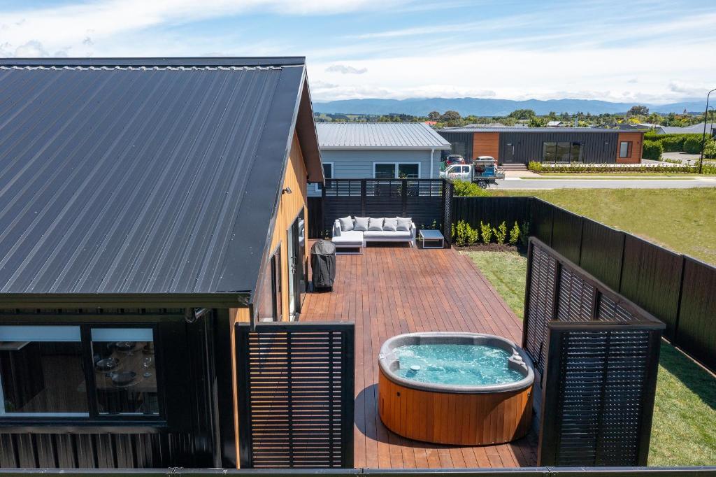The Green House - Luxury Eco Escape في مارتينبوره: السطح مع حوض استحمام ساخن فوق المنزل
