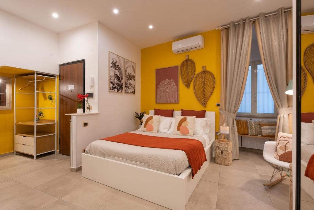 een slaapkamer met een bed en een gele muur bij Santalucia 36 in Napels