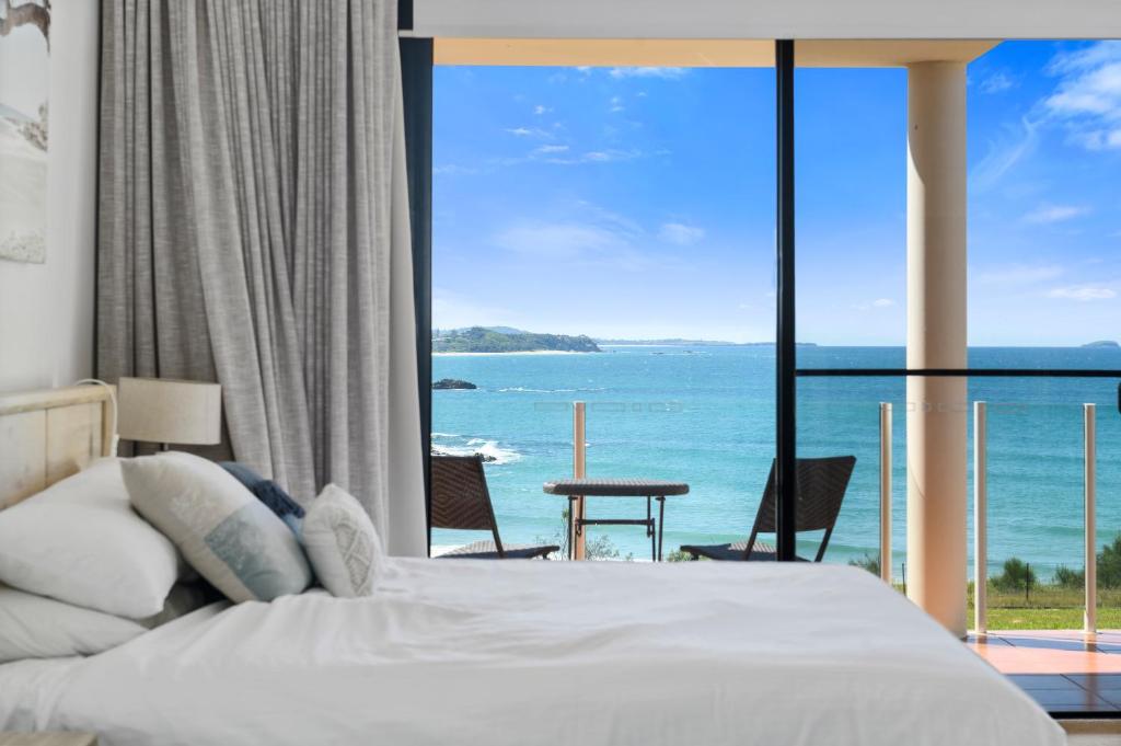 a bedroom with a bed and a view of the ocean at Villa Provence Coffs Harbour in Coffs Harbour