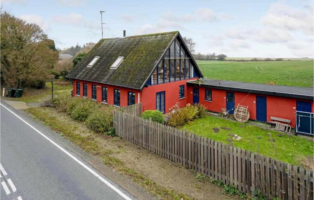 une maison rouge avec un toit noir à côté d'une route dans l'établissement Stunning Apartment In Tranekr With Wifi, à Tranekær