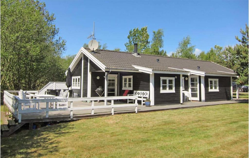una pequeña casa con un gran porche en el césped en 3 Bedroom Nice Home In Aakirkeby, en Vester Sømarken