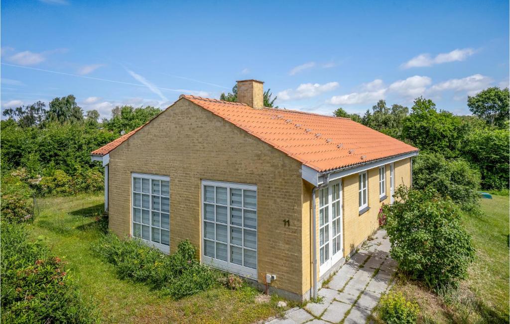 une petite maison en briques avec un toit orange dans l'établissement Lovely Home In lsted With Kitchen, à Ølsted