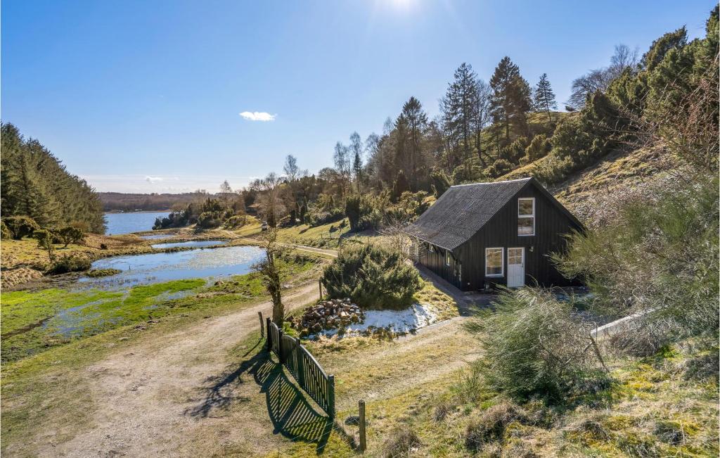a small cabin on a hill next to a river at Awesome Home In Hobro With Kitchen in Hobro