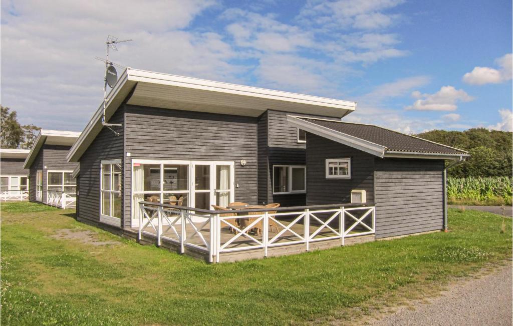 a black house with a porch on a lawn at Stunning Home In Gudhjem With Wifi in Gudhjem
