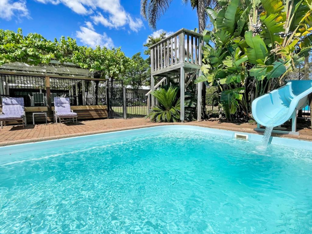 a swimming pool with a blue slide in a yard at Alfie's Place in Nulkaba