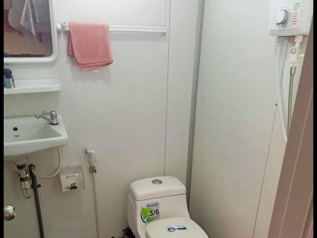 małą łazienkę z toaletą i umywalką w obiekcie บ้านสวนในเมืองปราจีนบุรี 