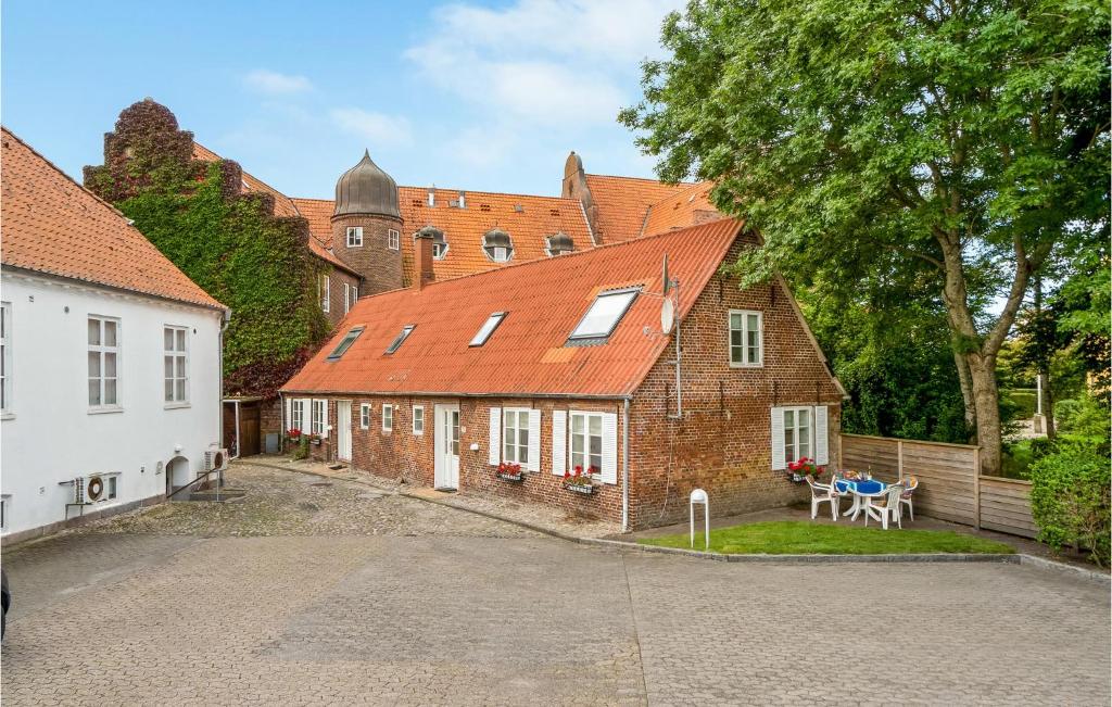 una vecchia casa di mattoni con un tavolo di fronte di 4 Bedroom Stunning Home In Tnder a Tønder