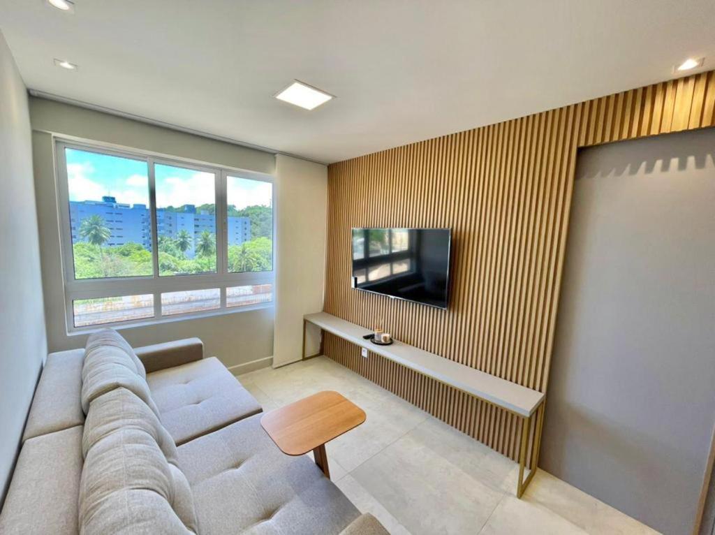 sala de estar con sofá y TV de pantalla plana en FS Confort - Flat Residence Mar, en João Pessoa