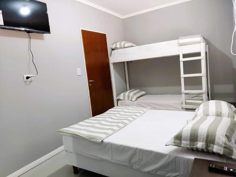 ein Schlafzimmer mit einem Etagenbett und einem TV in der Unterkunft Hotel Ruta 66 Oficial in Paso de los Libres