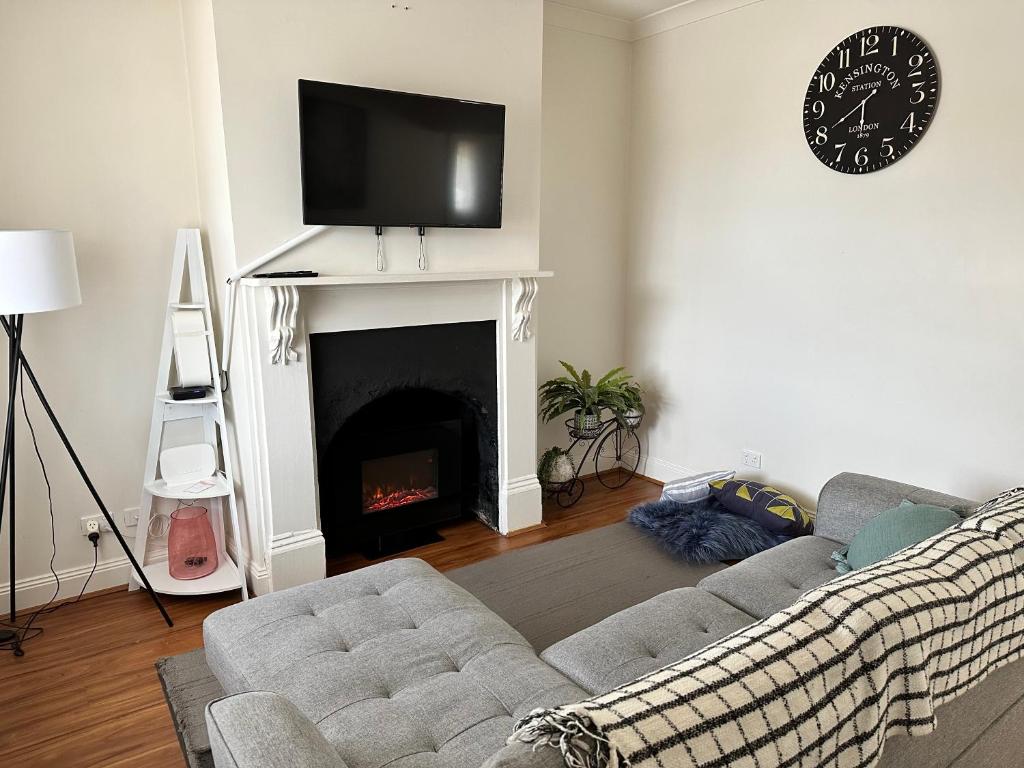 a living room with a couch and a fireplace at Cornelias Cottage Mount Gambier Central in Mount Gambier