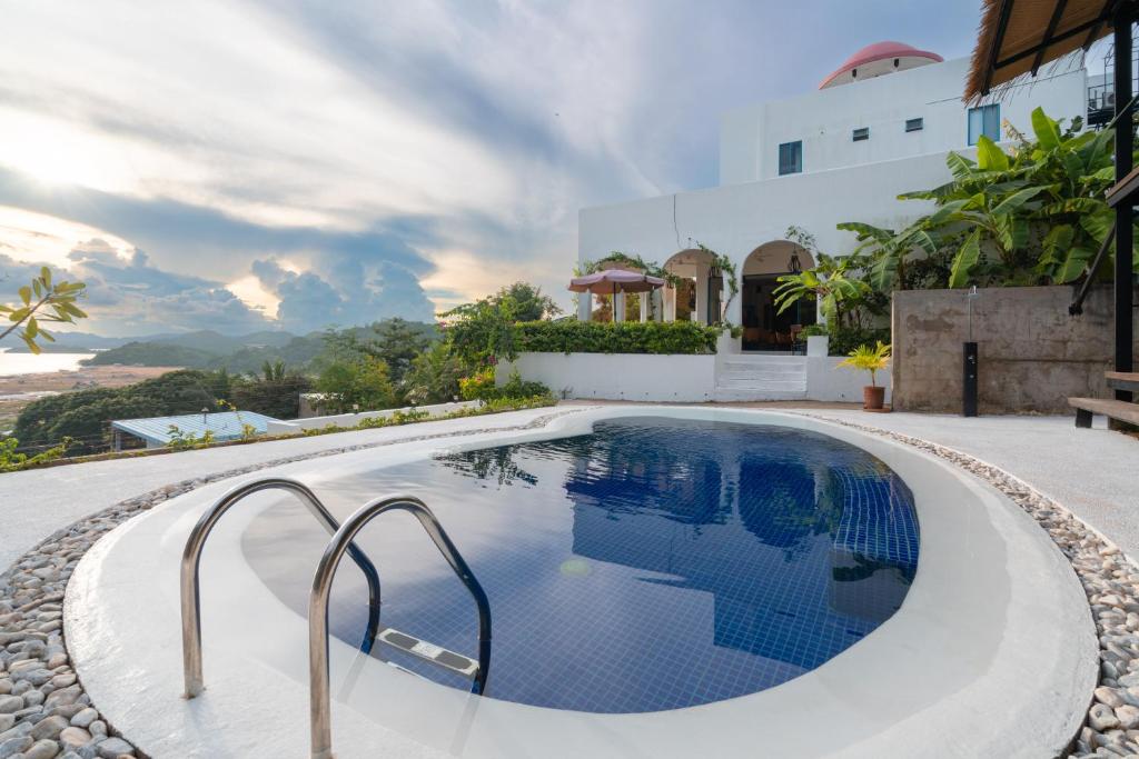 a swimming pool with a view of a house at Hop Hostel in Coron