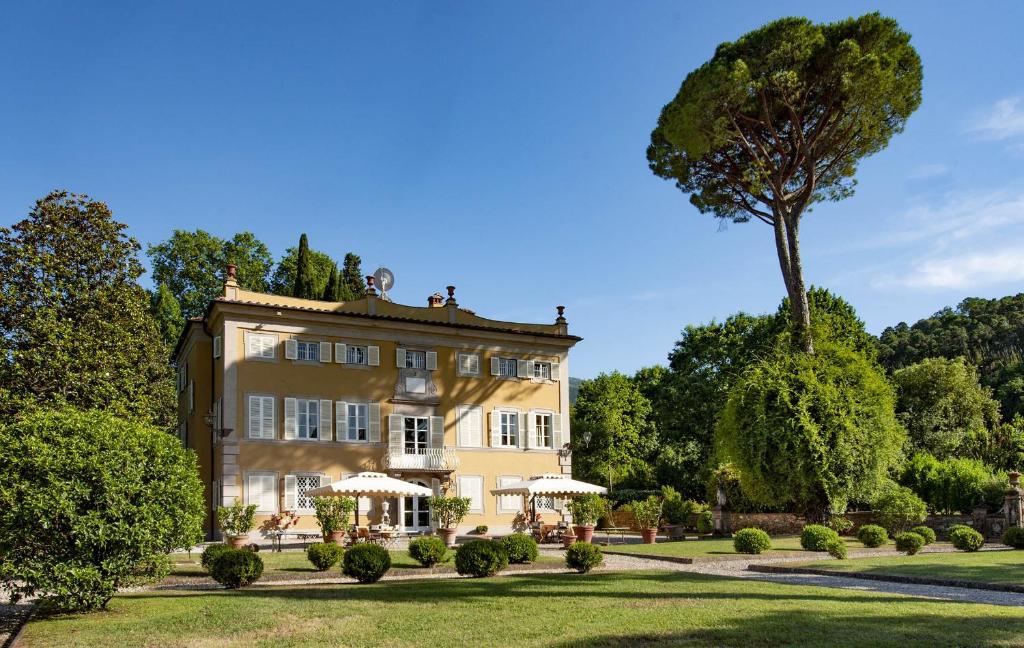 a large building with a tree in front of it at Coselli 's Collection. Luxury Villas Rental in Capannori