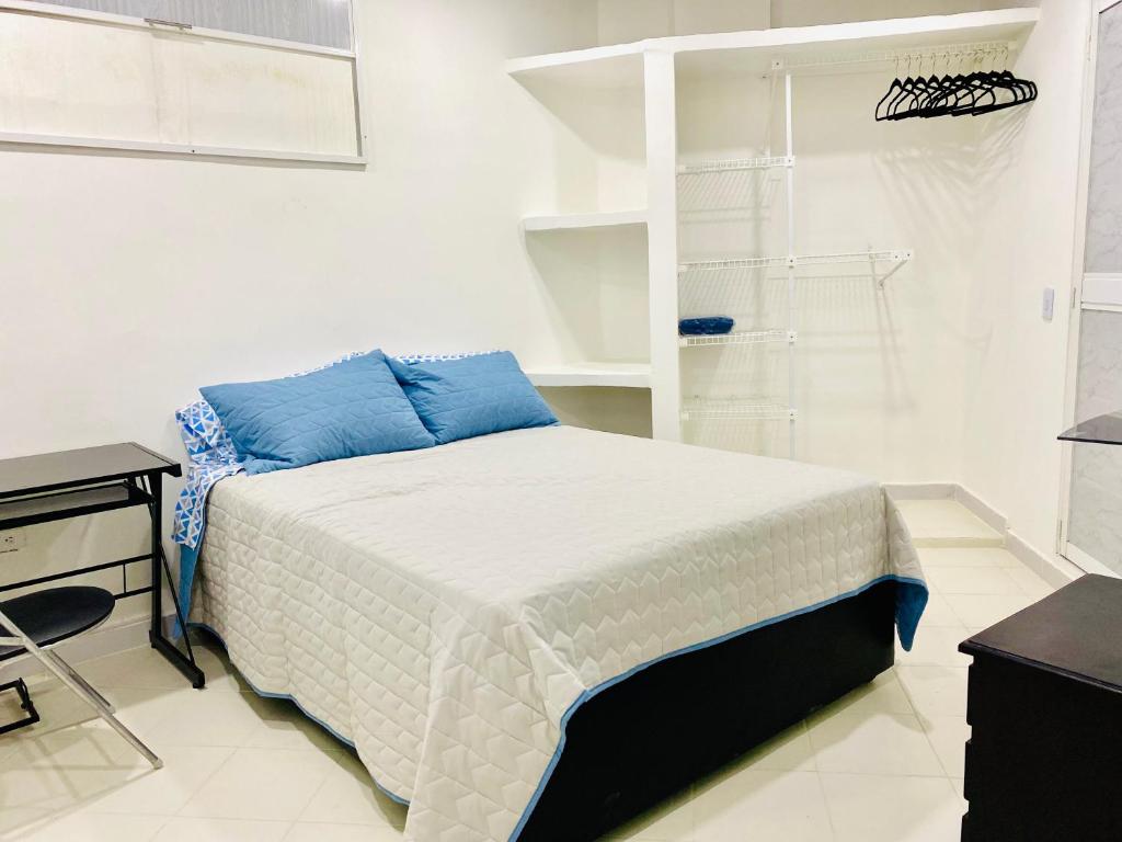 Un dormitorio con una cama con almohadas azules. en Hostal La Princesa, en Cartagena de Indias
