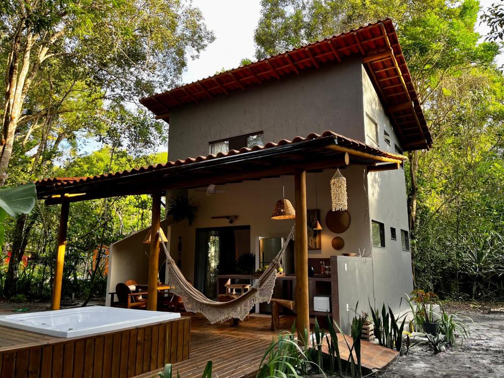 a house with a hammock in front of it at Casa Viva Trancoso in Trancoso