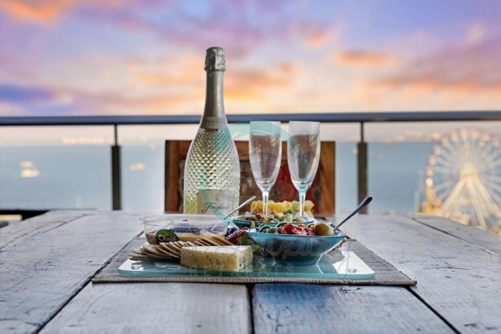 a table with a plate of food and wine glasses at ZEN POINT PENTHOUSE 3-BR Executive W/front Retreat in Darwin