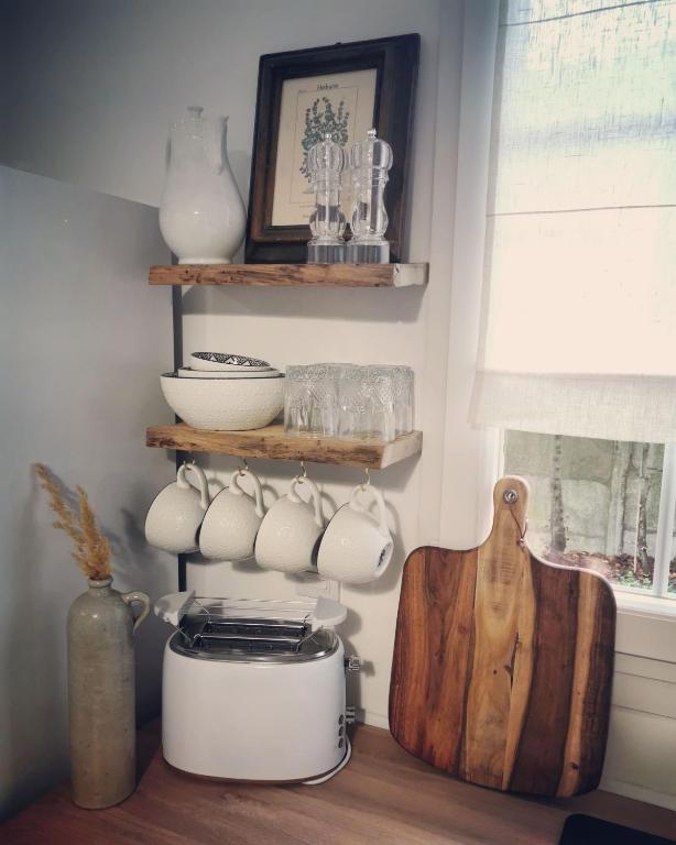 a kitchen with a shelf with bowls and a toaster at Hydrangea Cottage Arras in Saint-Laurent-Blangy