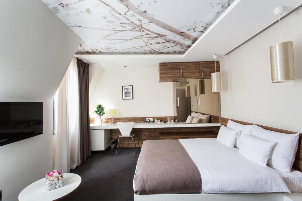 une chambre d'hôtel avec un lit et une cuisine dans l'établissement Hotel Sole, à Niš