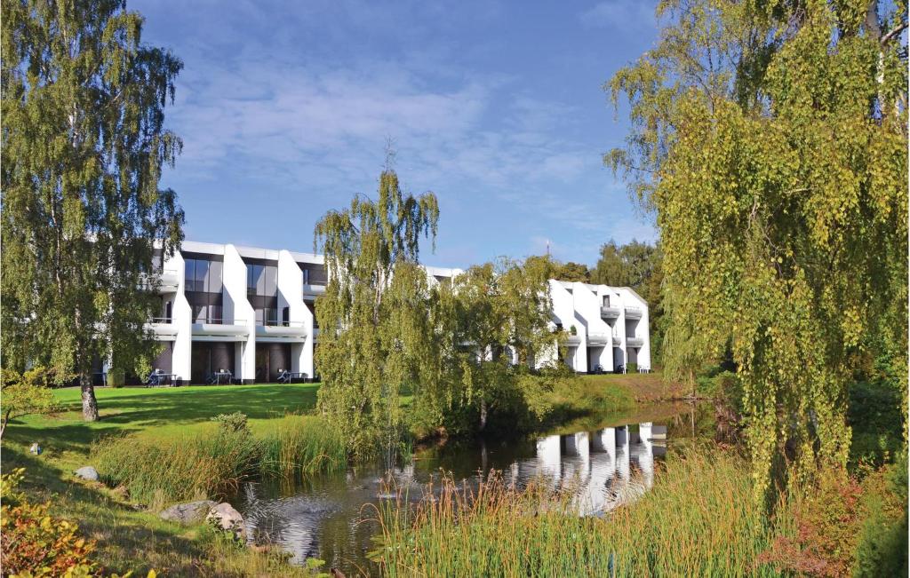 a white building with a pond in front of it at Amazing Apartment In Helsingr With Kitchen in Helsingør