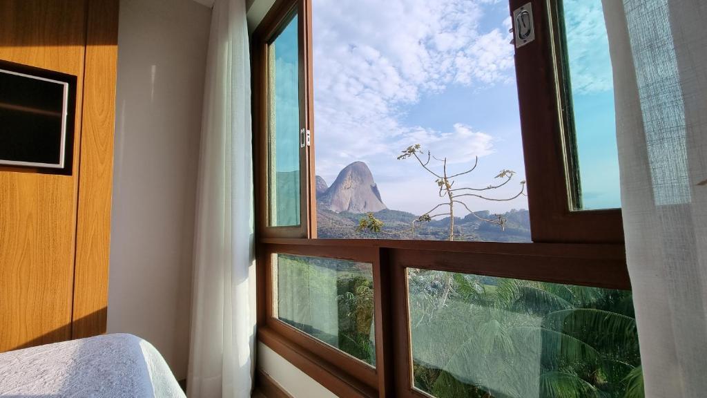 um quarto com uma janela com vista para uma montanha em Loft 335 Vista Azul em Pedra Azul