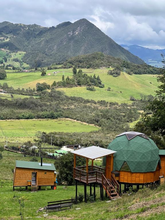 a gazebo and a tent on a field with a mountain at ReverdeSer Glamping in Tabio