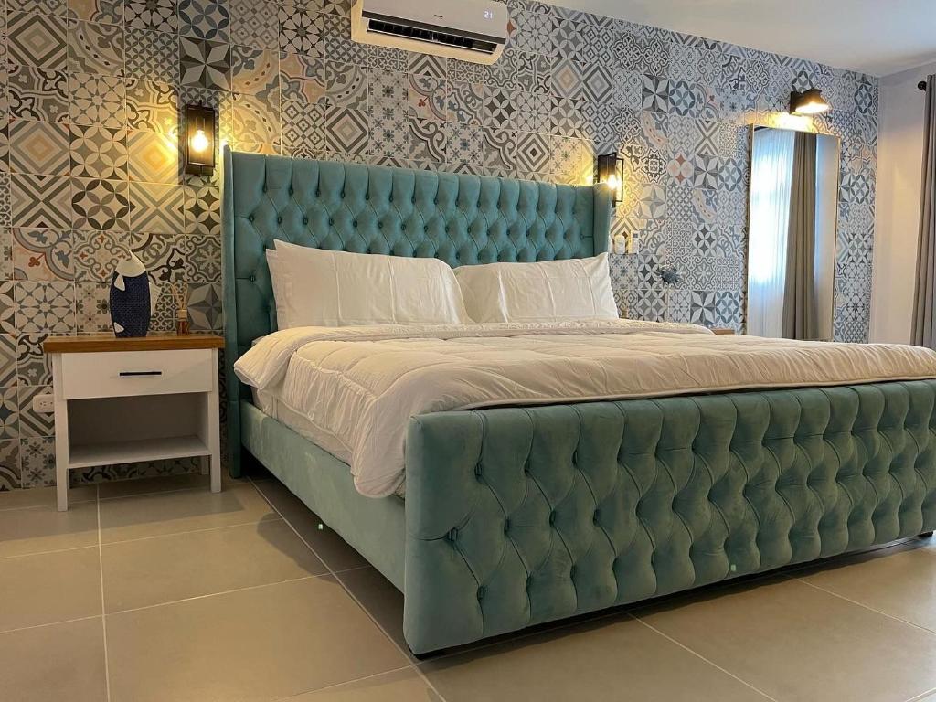 a large bed with a blue tufted headboard in a bedroom at Hotel Mono Azul in Quepos