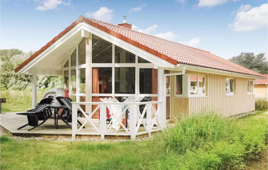 ein kleines Haus mit einer großen abgeschirmten Veranda in der Unterkunft Schmugglerstieg 7 - Dorf 6 in Travemünde