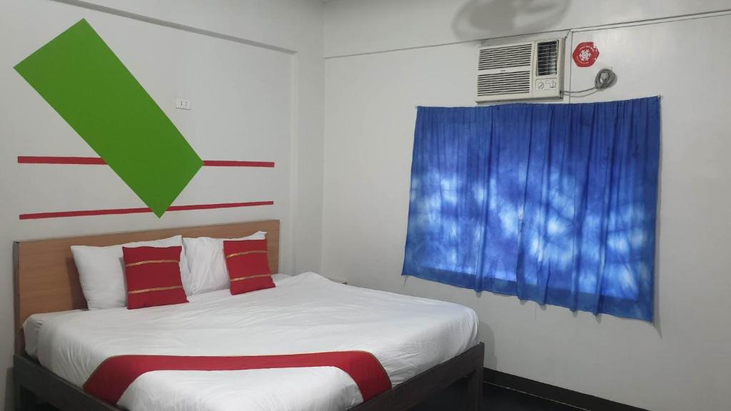 a bedroom with a bed and a window with a green arrow at Regal Residences in Manila
