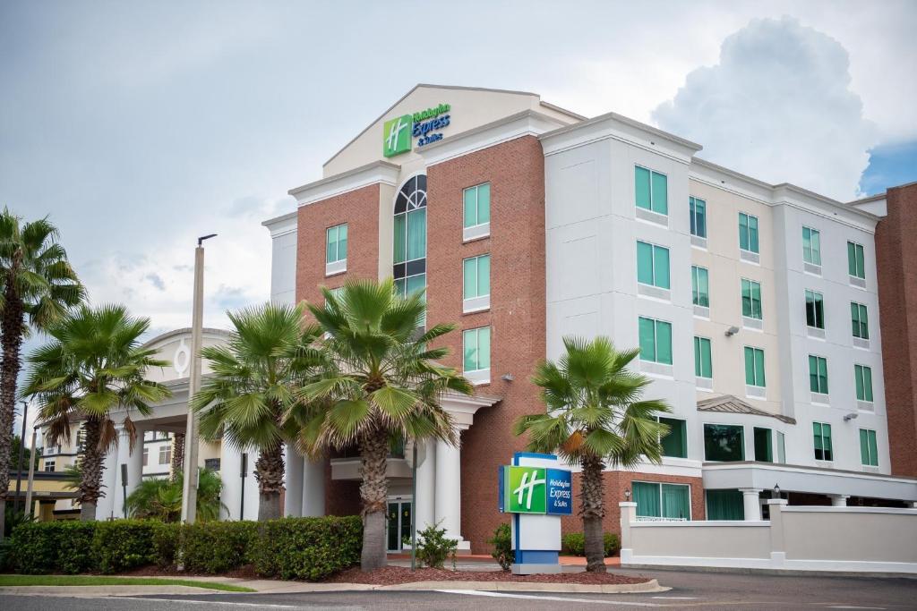 un hôtel avec des palmiers devant lui dans l'établissement Holiday Inn Express Hotel & Suites Chaffee - Jacksonville West, an IHG Hotel, à Jacksonville